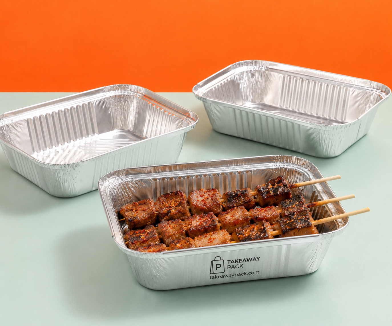 Kraft skewer boxes and aluminium foil containers with barbecue skewers on a dark table