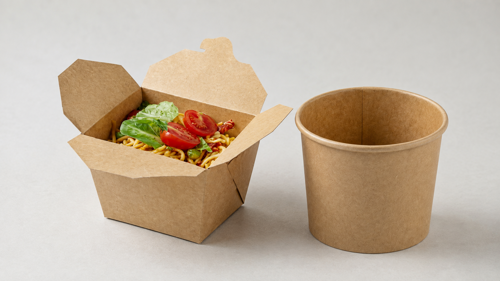 Kraft paper food containers and cups arranged on a stainless steel prep counter