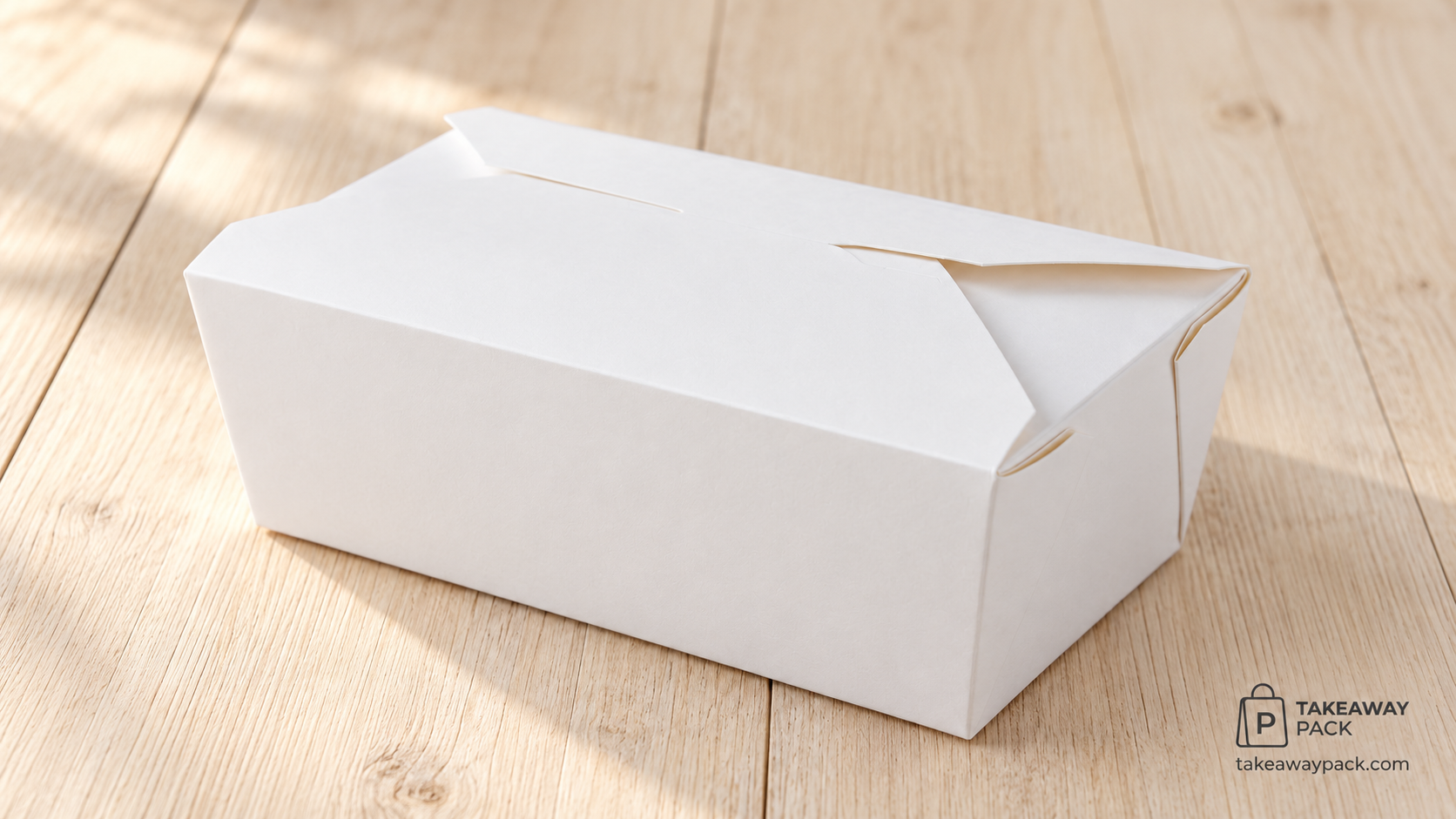 Closed plain white rectangular paper takeaway food box on a sunlit light wooden surface.
