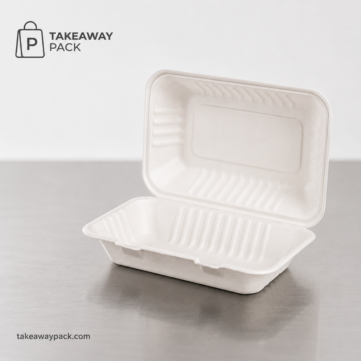 Open white molded-fiber clamshell takeaway box on a metal counter