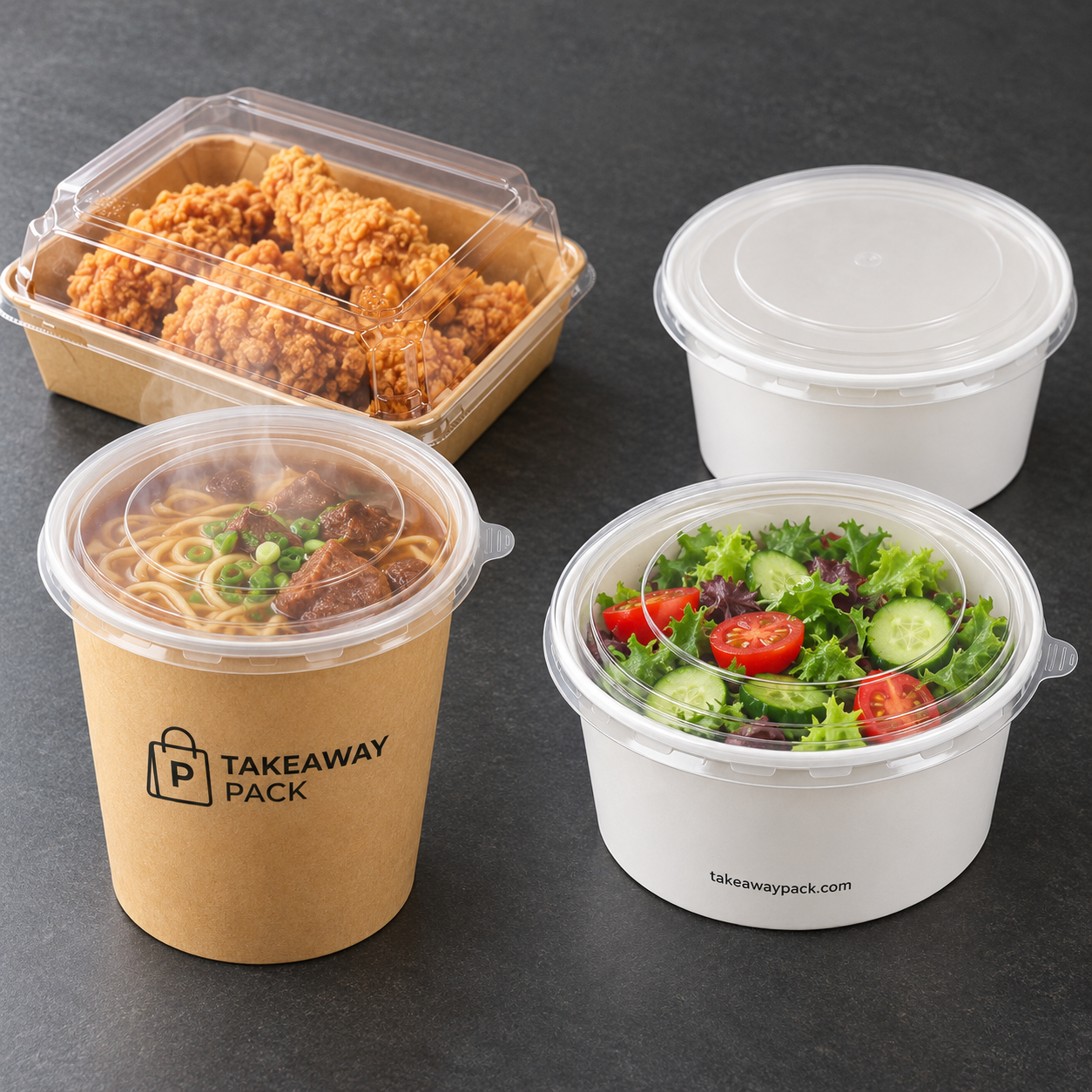 Four food containers on a dark grey counter: a pulp box of fried chicken with a clear lid, an empty white round box, a brown printed cup of noodle soup, and a white box of salad.