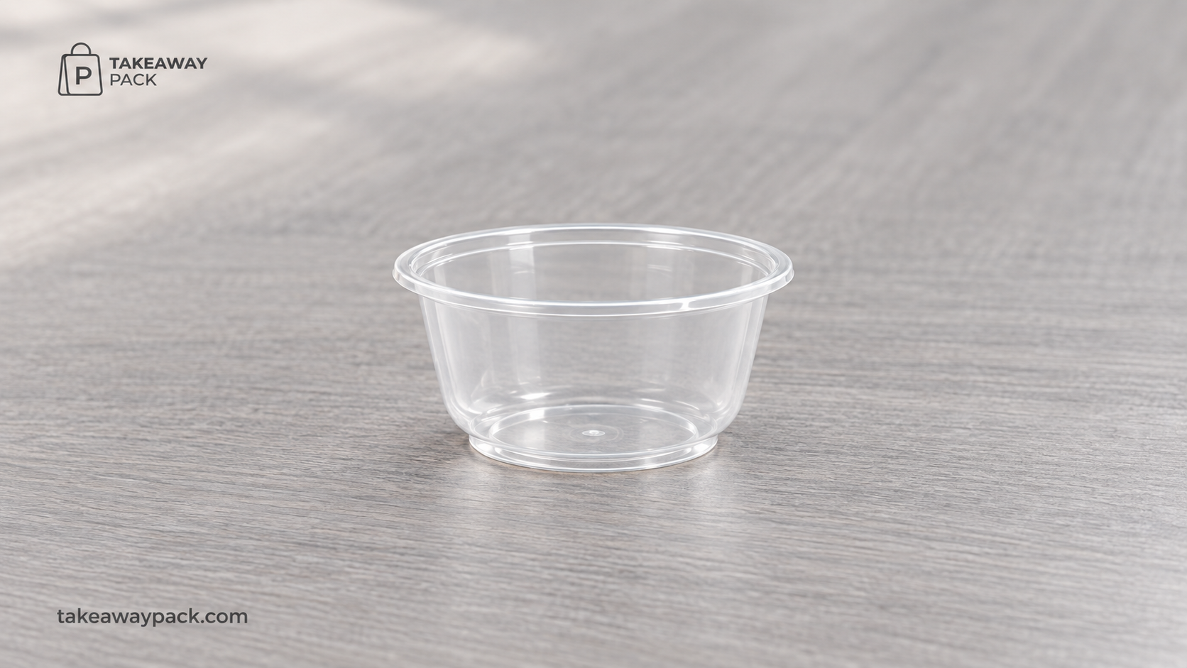 Clear round plastic takeaway bowl on a wood-grain surface.